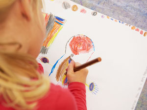 Ein Kind malt liebevoll ein Bild